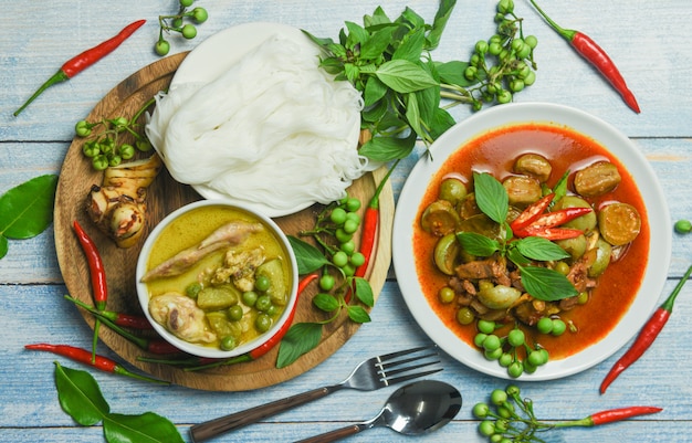 Green and red curry on a wooden table