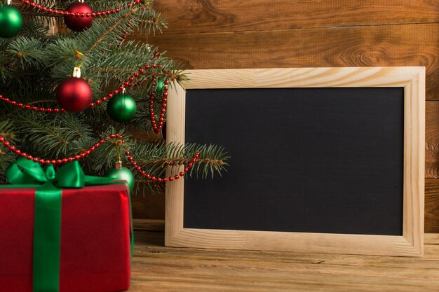 緑赤の贈り物と木の下の黒板