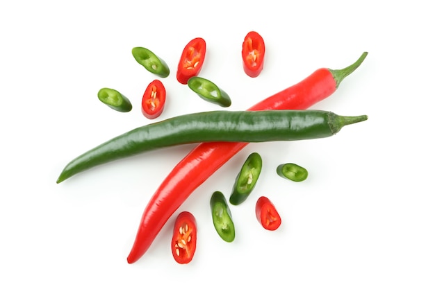 Green and red hot chili peppers and slices isolated on white