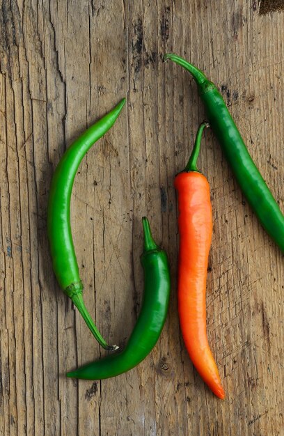 Green and red peppers on dark wooden background Above view Dark and moody atmosphere