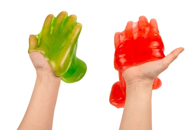 Green and red slime toy in woman hand isolated on white. Top view.