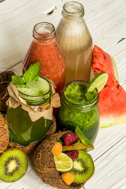 Green and red smoothies in a jar with lime