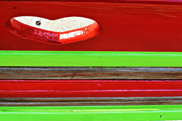 Photo green and red striped bench with heart abstract view