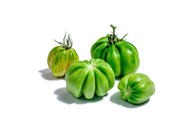 Green ribbed tomatoes isolated on white background American or Florentine variety