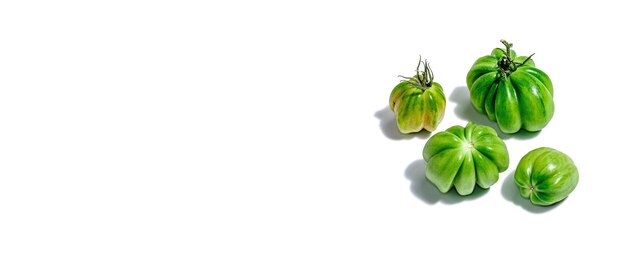 Green ribbed tomatoes isolated on white background American or Florentine variety