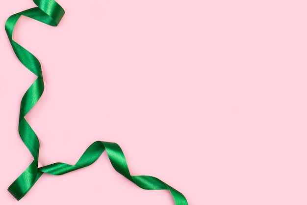 A green ribbon on a pink background