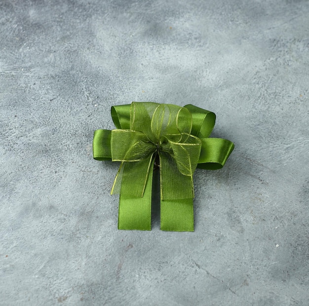 Green ribbon with a bow as a gift on a white and black background