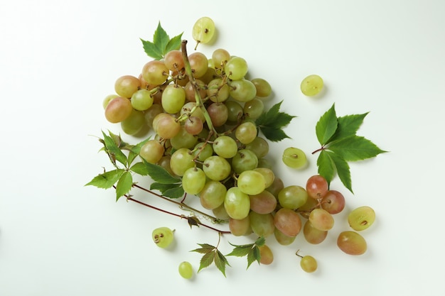 Зеленый спелый виноград с листьями на белом фоне