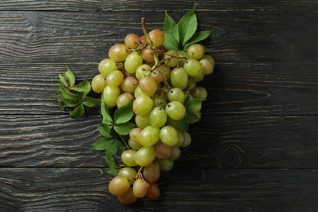 Green ripe grape on wooden background, close up