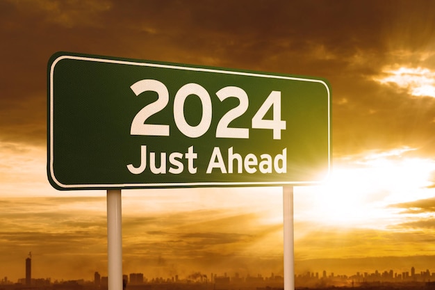 Зеленый дорожный знак с текстом 2024 года впереди во время восхода солнца
