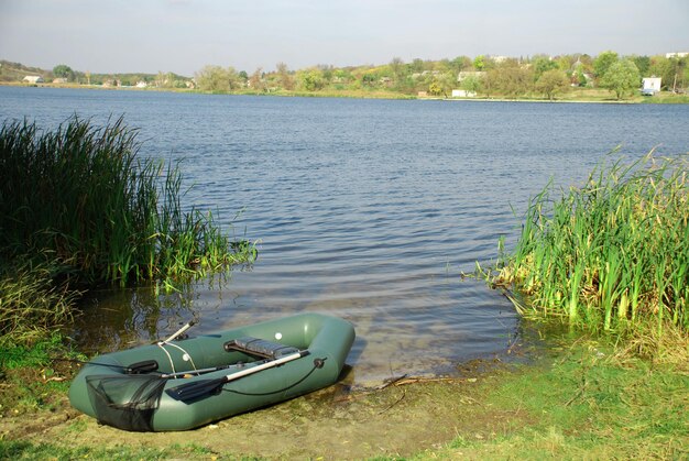 Green rubber boat at the river beach