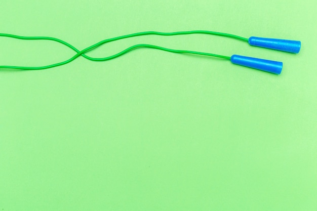 Green rubber jumping rope with blue handles top view