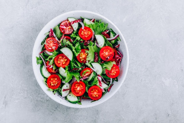 Зеленая салатница с помидорами, огурцами, красным луком, радиккио и свежим салатом Здоровое питание Вид сверху с копией пространства