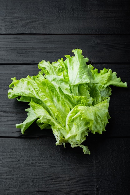 Green salad lettuce fresh leaves, on black wooden table