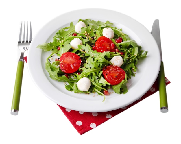 Green salad made with arugula tomatoes cheese mozzarella balls and sesame on plate isolated on white