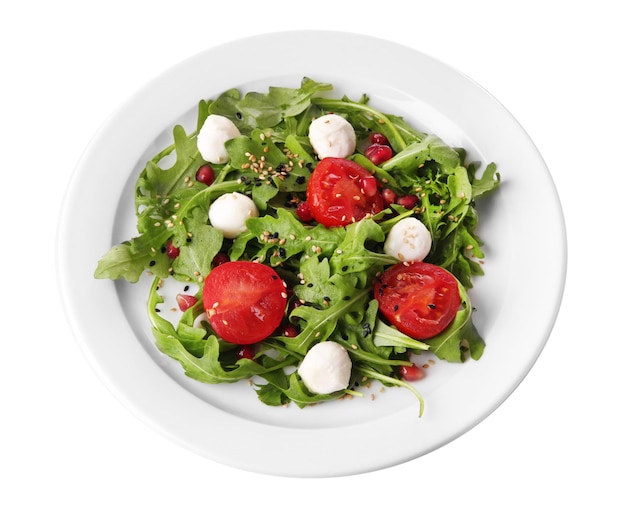 Green salad made with arugula tomatoes cheese mozzarella balls and sesame on plate isolated on white