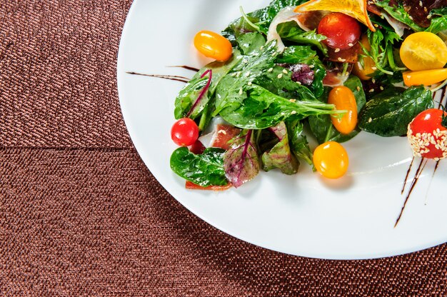 Green salad topped with yellow tomatoes.Top view