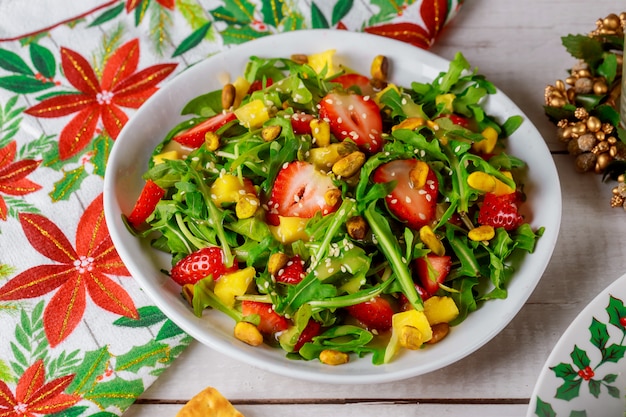 Green salad with arugula, strawberries, pineapple and pistachios Christmas content.