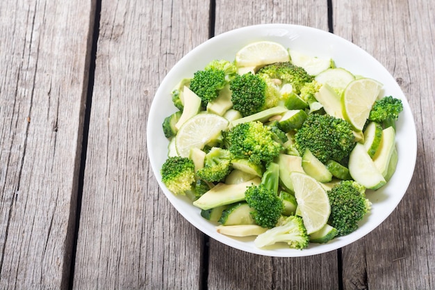 Green salad with avocado broccoli cucumber and lime Healthy vegetarian salad