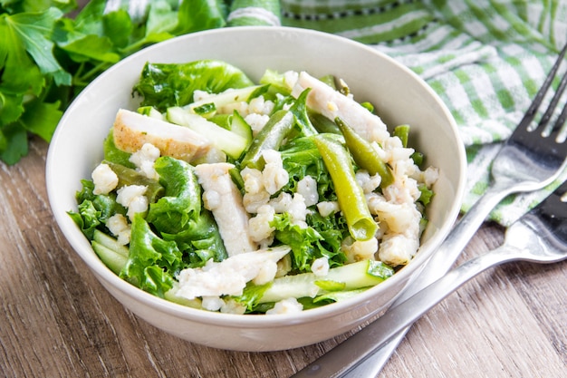 Green salad with chicken, pearl barley, fresh cucumber, French beans, wholesome hearty lunch