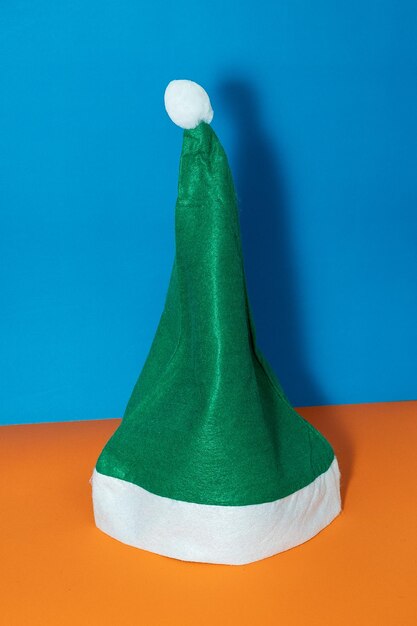 Green santa hat on orange and blue background