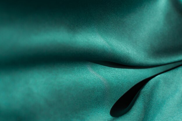 Green satin fabric pleats closeup Abstract trend background of the 2021 Tidewater Green color