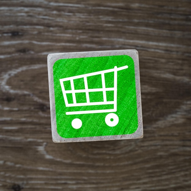 A green shopping cart sign symbol or icon representing store retail and consumerism and copy space