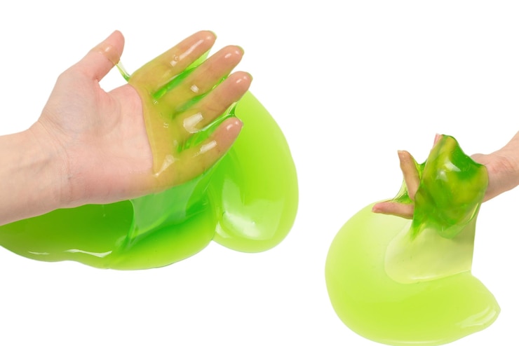 Photo green slime toy in woman hand isolated on white background