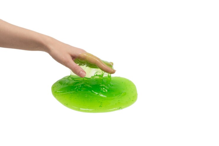 Photo green slime toy in woman hand isolated on white background.