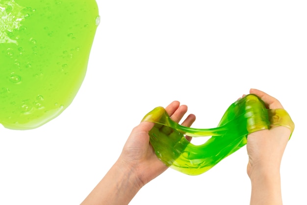 Green slime toy in woman hand isolated on white. Top view.