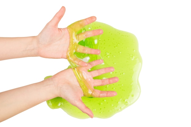 Green slime toy in woman hand isolated on white. Top view.