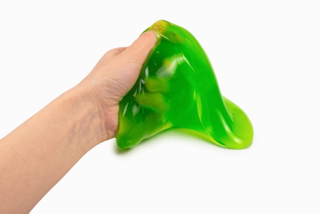 Green slime toy in woman hand isolated on white. Top view.