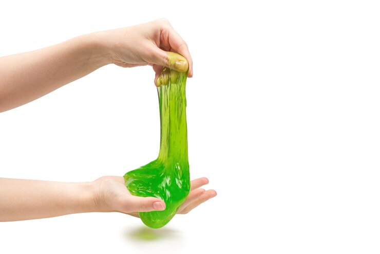 Photo green slime toy in woman hand isolated on white.