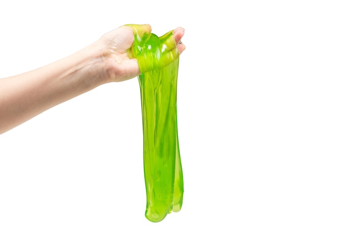 Photo green slime toy in woman hand isolated on white