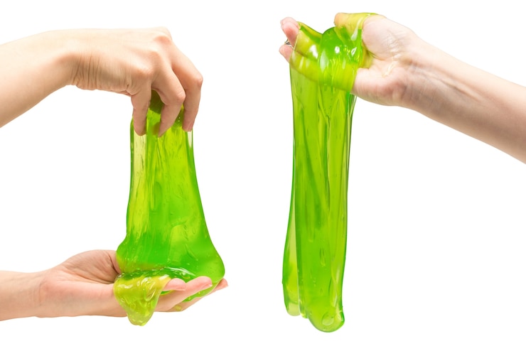 Photo green slime toy in woman hand isolated on white.