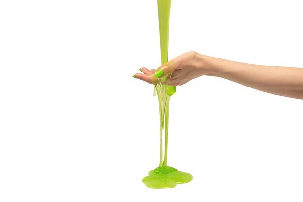 Green slime toy in woman hand with green nails isolated on a white background