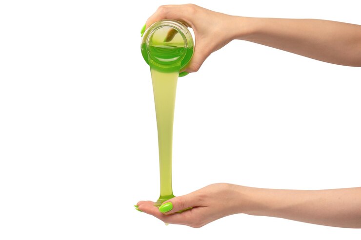 Photo green slime toy in woman hand with green nails isolated on a white background
