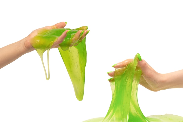 Photo green slime toy in woman hand with green nails isolated on a white background