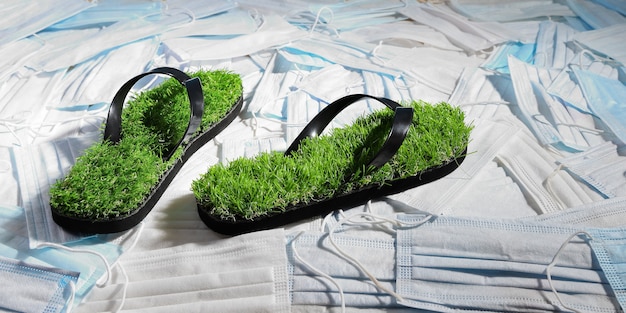 Green slippers, with imitation grass on the surface of medical masks that pollute the planet