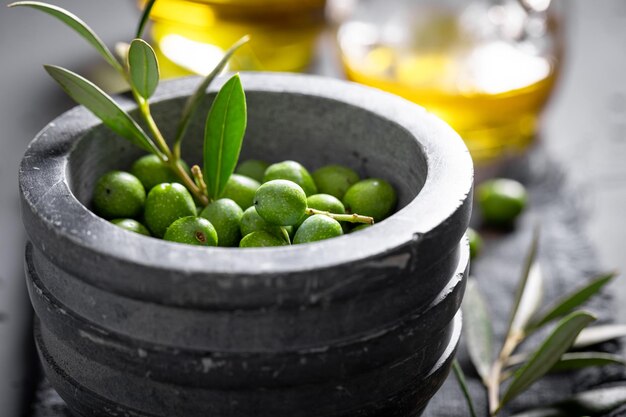 Green and small raw olives with berries and oil