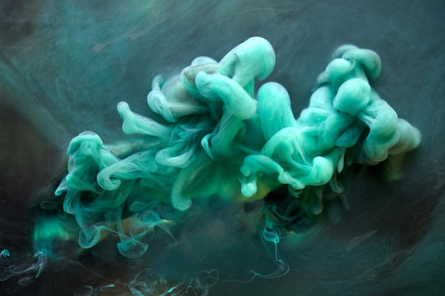 緑の煙の抽象的な背景のアクリル絵の具の水中爆発