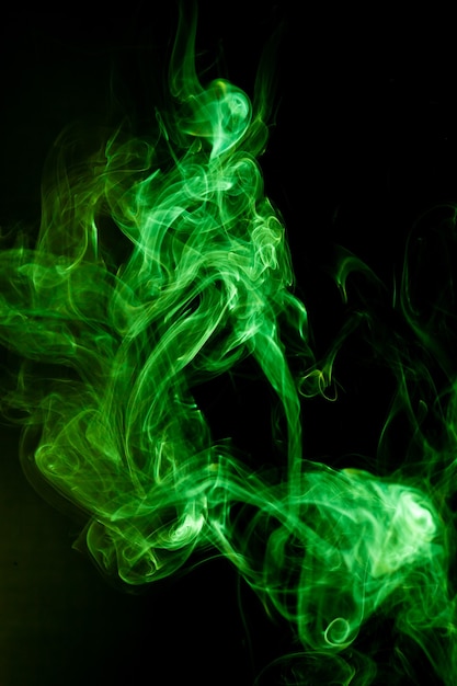 Green smoke motion on black surface.