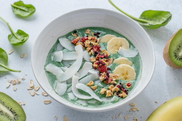 Green smoothie in bowl with fruits