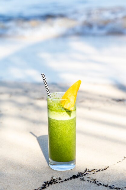 Green smoothie cocktail on beach