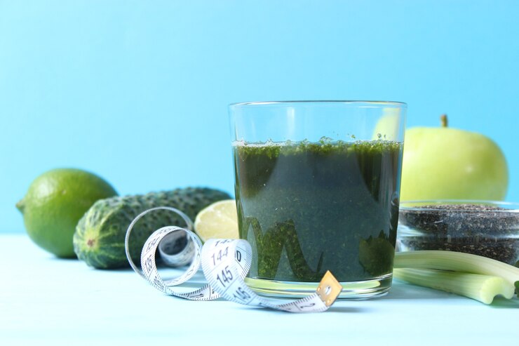 Photo デトックス生物のためのテーブルの上の緑のスムージーと新鮮な野菜