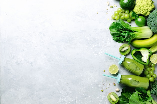 Green smoothie in glass jar with fresh organic green vegetables and fruits 