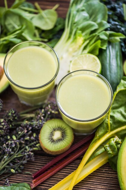 Green smoothie and ingredients on wooden table