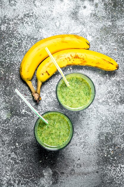 Photo green smoothie with spinach and banana. on rustic background.