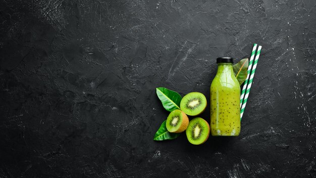 Green Smoothies with fresh kiwi and kiwi on a black background Wooden Rustic style Fruits Top view Free space for text