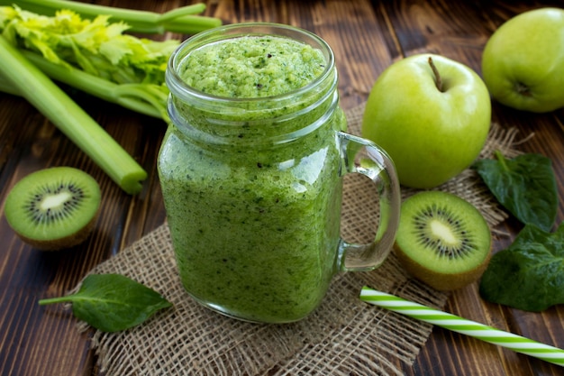 Green smoothies with fruits and vegetables on the rustic wooden